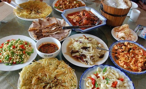 Traditional Chinese food laid out on many plates.