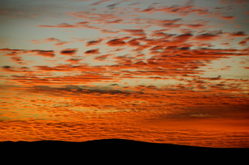 Red and orange sunset in Mauritania above the sand dunes.