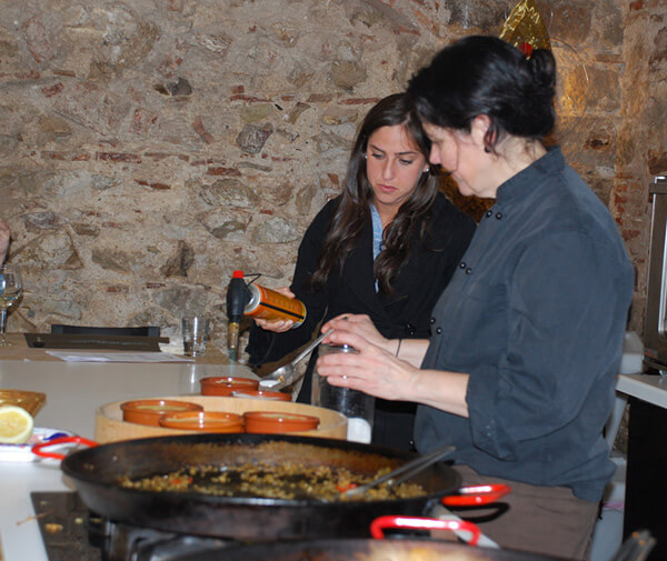 Barcelona cooking class with teacher Teresa showing a student how to make 'crema Catalan.'