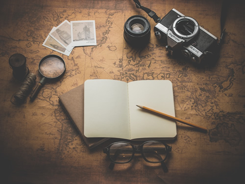 Freelance travel writing tools including a notebook and a camera.