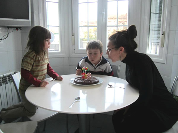 Blowing out birthday candles in Madrid home with children.