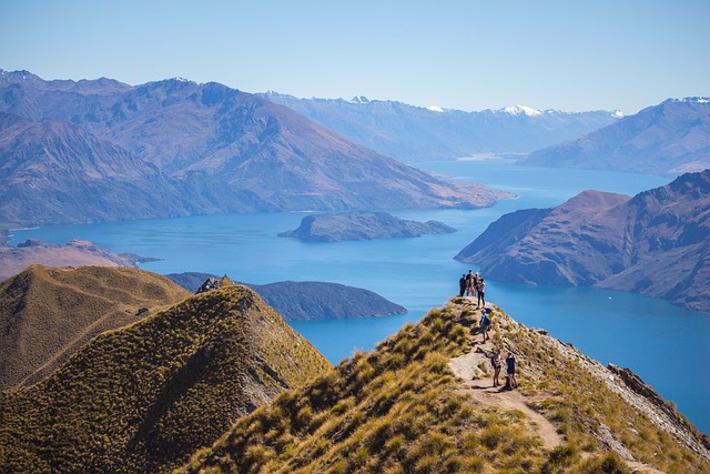 Group standing on Roy's Peak in New Zealand with water below.