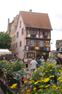 A house in Colmar, Alsace, with flowers along the river.