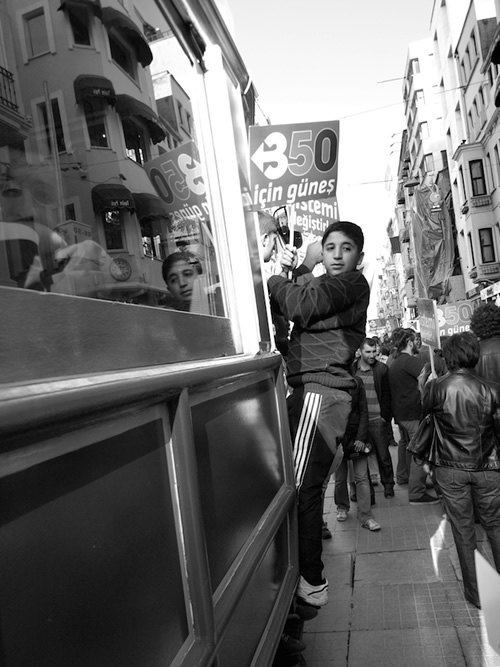 Boy holding onto a bus in Istanbul.