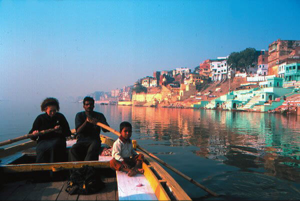 Teen rowing on the river Ganges in India.