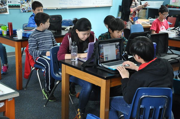 Young students in China at the computer in a classroom.