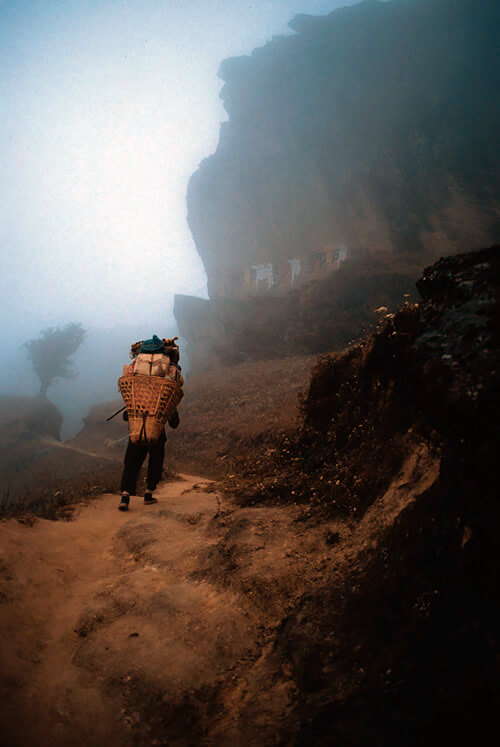 A mountain porter climbing in Nepal.