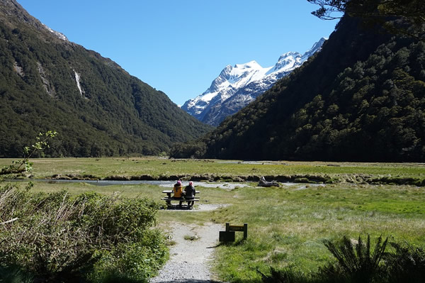 Natural wonders in New Zealand, sitting in a valley with snow-covered mountains above the greenery.