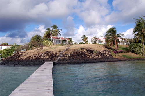 A bridge across water leading to a house in the Martinique.