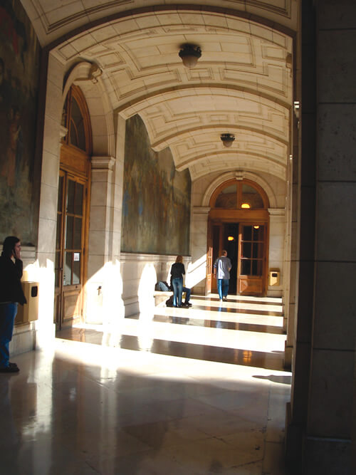 Study Abroad in Paris at the Sorbonne with a view of students in an interior classroom hallway.