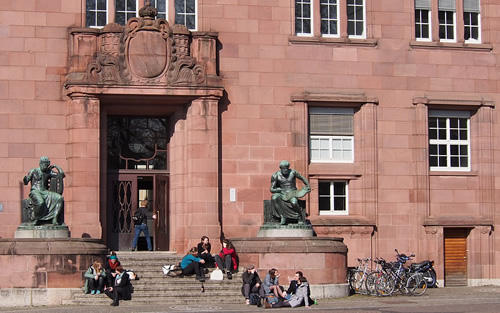 Students sitting in front of a school building in Germany.